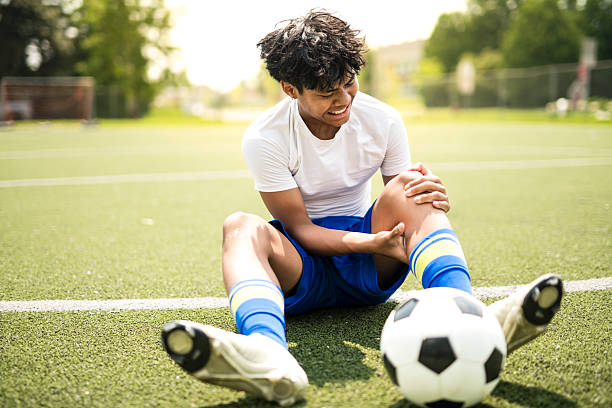 istock nice Boy with soccer ball outside on field having injury 2243814092