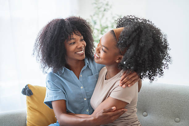 istock Affectionate mother and daughter sitting on sofa at home 2243815569