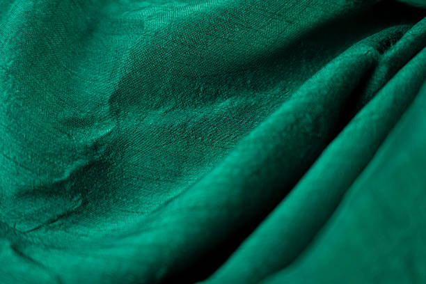 istock Shiny Green Fabric Draped with Artistic Lighting 2243815772