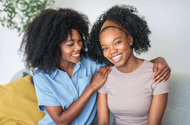 istock Affectionate mother and daughter sitting on sofa at home 2243818852