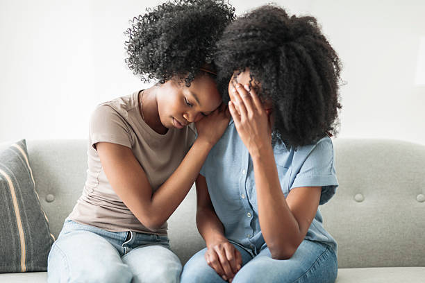 istock Affectionate mother and daughter sitting on sofa at home 2243818973