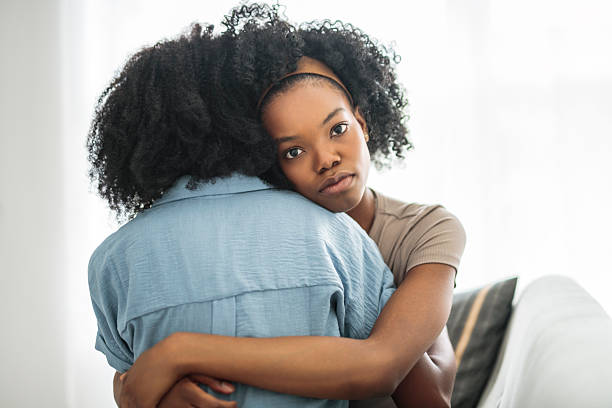 istock Affectionate mother and daughter sitting on sofa at home 2243818982