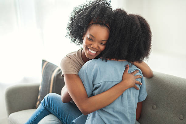 istock Affectionate mother and daughter sitting on sofa at home 2243818988