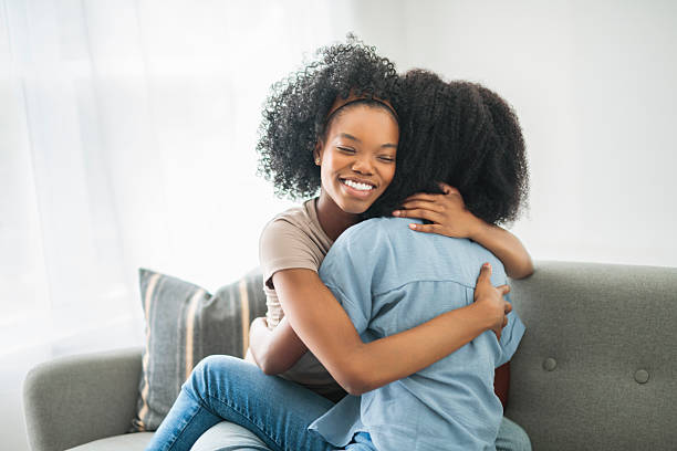 istock Affectionate mother and daughter sitting on sofa at home 2243819002