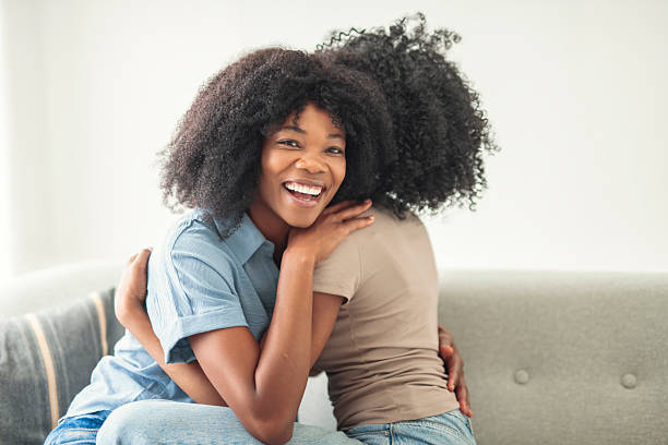 istock Affectionate mother and daughter sitting on sofa at home 2243819004