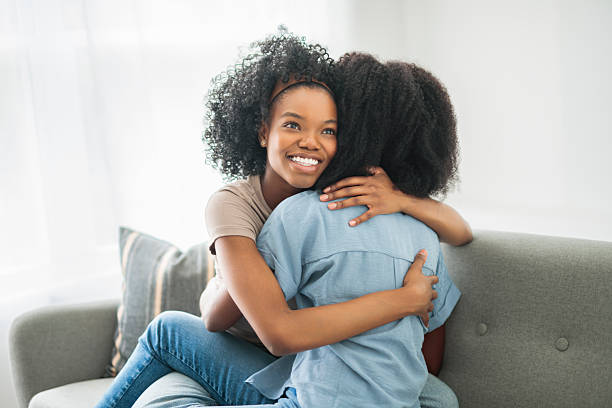 istock Affectionate mother and daughter sitting on sofa at home 2243819005