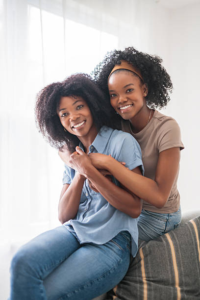 istock Affectionate mother and daughter sitting on sofa at home 2243819015