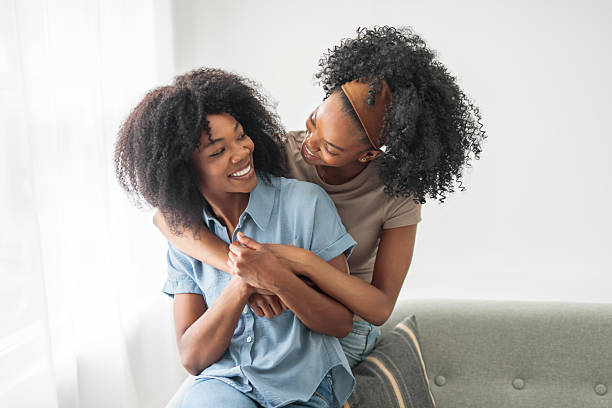 istock Affectionate mother and daughter sitting on sofa at home 2243819017