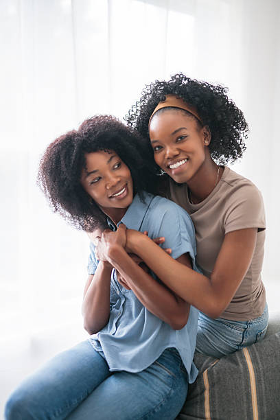 istock Affectionate mother and daughter sitting on sofa at home 2243819019