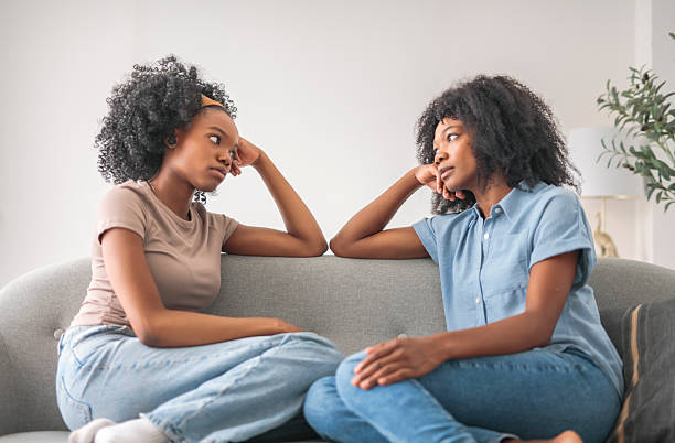 istock Affectionate mother and daughter sitting on sofa at home 2243819035