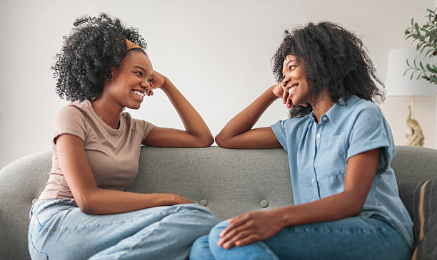 istock Affectionate mother and daughter sitting on sofa at home 2243819040
