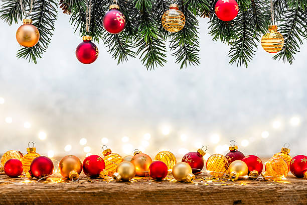Christmas decoration background with copy space. Cozy atmosphere or warm lights, colored Christmas balls and pine branches making a frame. December or greeting card