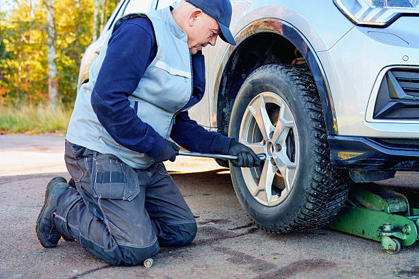 istock Senior man changing car tire on backyard. 2243821182