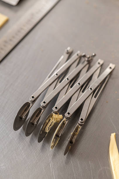 Accordion pastry cutter tool resting on a stainless steel kitchen table
