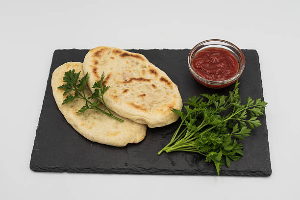 istock Homemade flatbread with parsley and tomato sauce on slate plate 2243826564