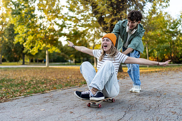 istock Young couple having fun skateboarding in park 2243826815