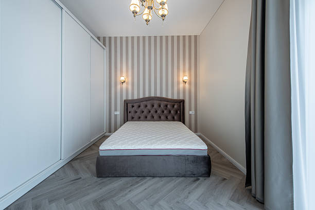 istock Elegant Home Bedroom Interior with Upholstered Bed and Striped Wall Decor 2243830396
