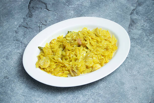 Alu Bhaji or golden poha, a delightful Indian breakfast or snack, beautifully presented in a crisp white bowl, perfect for culinary inspiration.