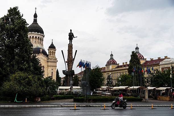 Old buildings, Orthodox church, European Union flag and pigeons on town square in Timisoara