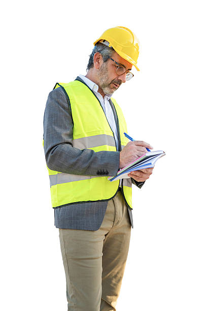 istock Engineer man wearing hard hat safety vest writing notes 2243838703