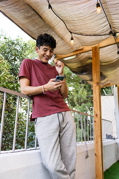 istock Young man using his smartphone in a terrace while eating a snack 2243839116
