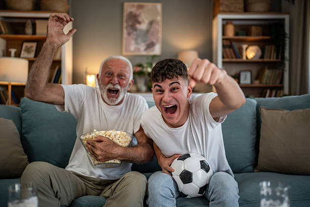 istock Grandfather and grandson cheering watching soccer 2243844629