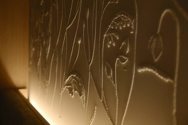 Photo of the surface of a luminous wall with three-dimensional shapes of triangles, lines and squares. Abstract design background.