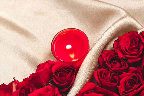 istock Romantic candle and red roses on a soft fabric for a special occasion 2243848172