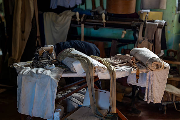 Antique Ironing Board with Vintage Clothes and Old Iron in Traditional Tailoring Workshop