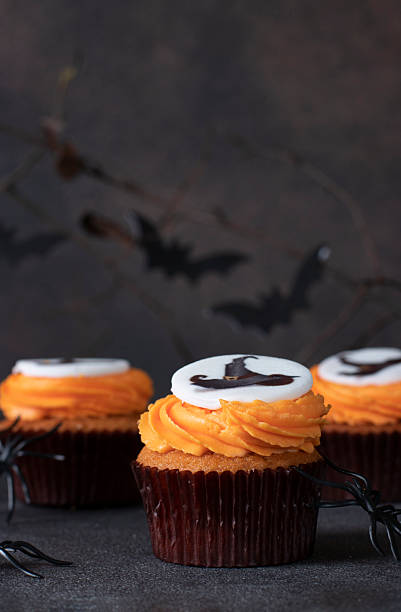 istock Bright sweet cupcakes with cream for Halloween celebration on brown background 2243854545