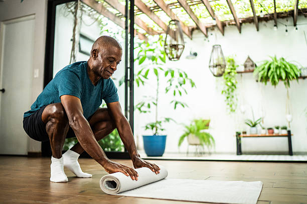 istock American senior man rolling carpet after home workout 2243854847