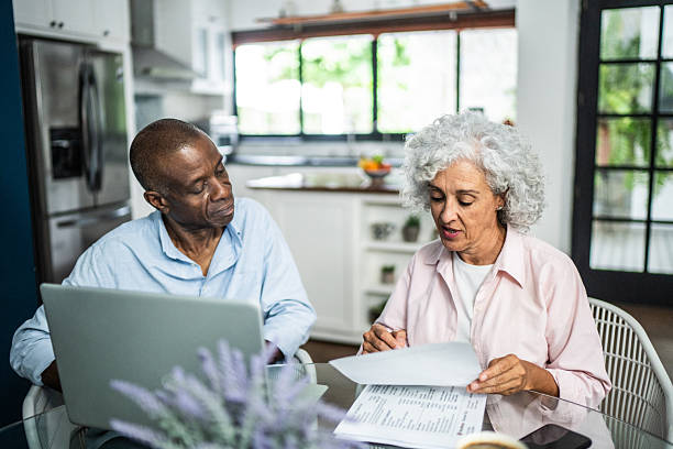 istock American senior couple talking and using laptop at home 2243855334