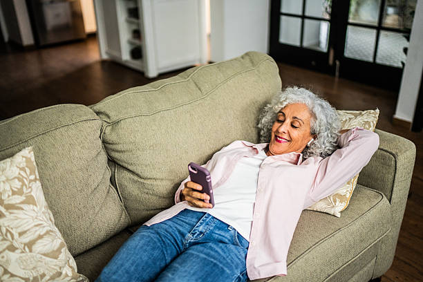 istock American senior woman using mobile phone at home 2243855412