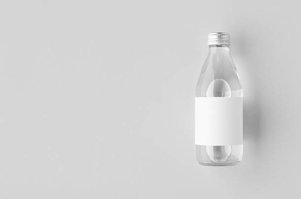 istock Small water bottle mockup with blank label, clear glass, copyspace 2243856534