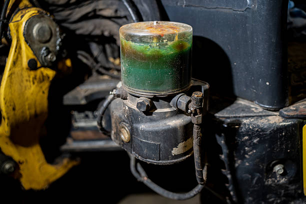 Automatic grease lubrication reservoir on industrial machinery showing transparent container with lubricant level, metal mount, and precision engineering for heavy equipment maintenance systems