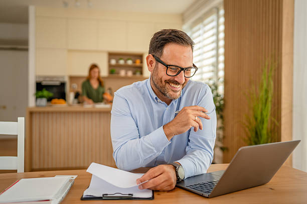 istock Happy man working remotely on laptop at home 2243858324