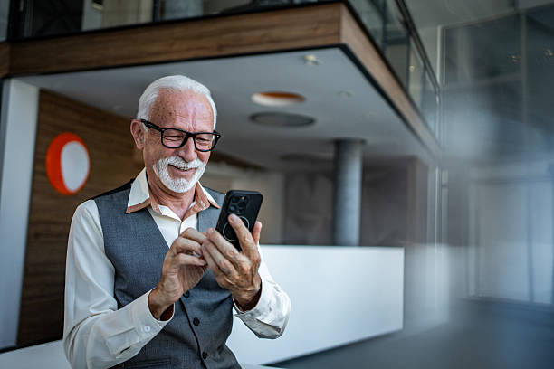 istock Senior businessman using smartphone and smiling in modern office 2243859810