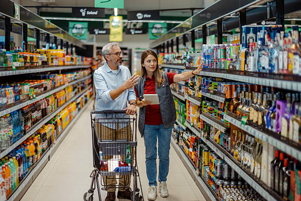 istock Female Supermarket Worker Helping Senior Shopper 2243860142