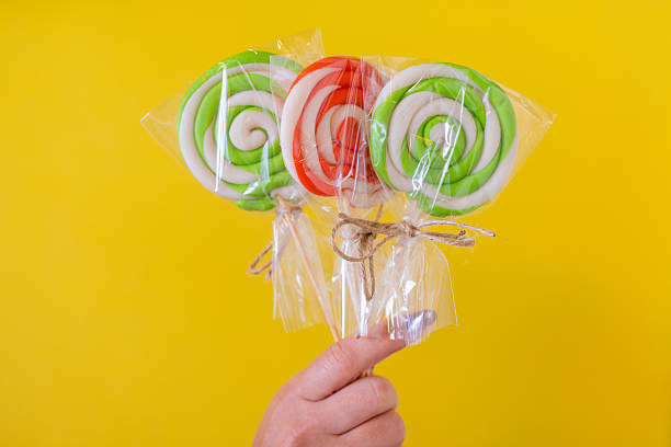 istock A woman holding a colorful candy in hand. 2243861271