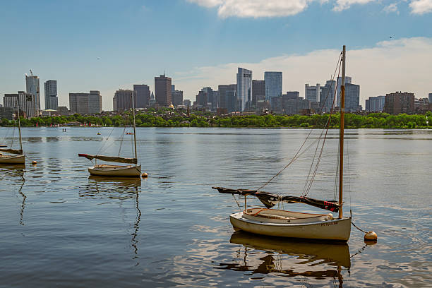 Cambridge, MA, US-July 15, 2025: View of the skyline of Boston from Cambridge with the Charles River and small sailboats in foreground.