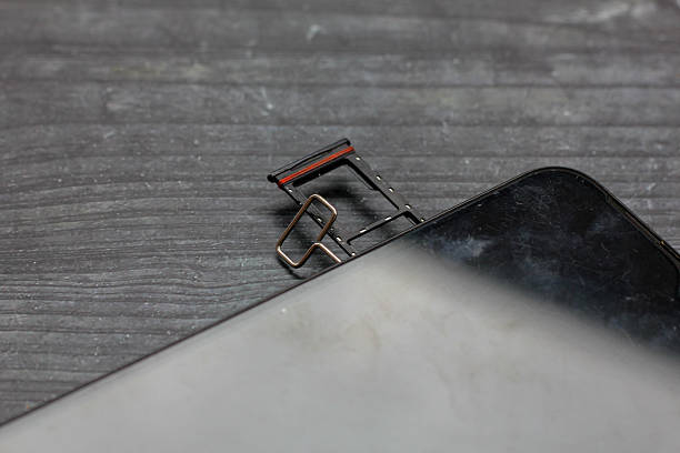 istock Dual nano simcards slot opens with wire lock on a black wooden board 2243861663