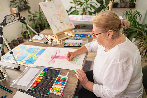 istock Senior Illustrator Drawing in Plant-Filled Studio 2243861827