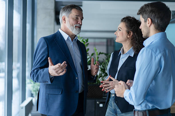 istock Three busy coworkers discussing project, standing in modern office 2243865467