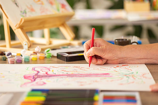 istock Close-Up of Elderly Woman’s Hands Drawing Colorful Illustration 2243865740