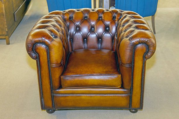 Stylish empty armchair standing in the corner of a room with wallpapered walls