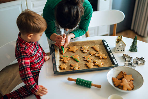 istock Little helper and his mom decorating Christmas cookies with icing. 2243874821