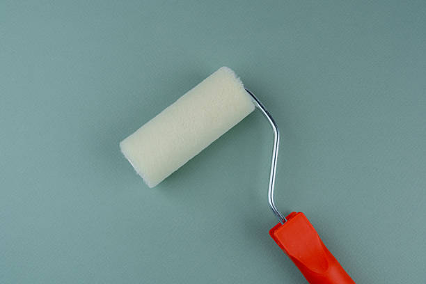 istock Paint roller with red handle on green background for interior painting and DIY improvement concept 2243875100