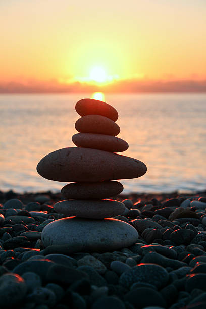 istock Stacked stones pyramid on the beach at sunset 2243877194