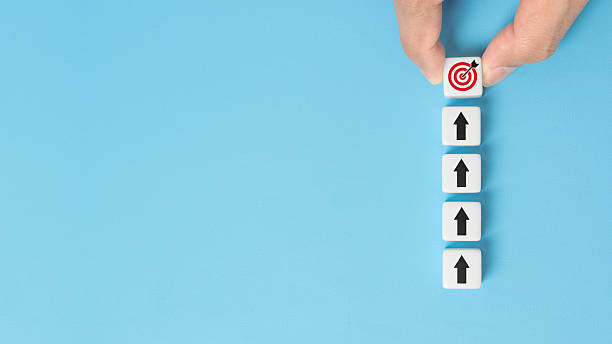 istock Hand holding dice with target aiming dart board and arrow up on blue background. Business achievement objective goal and project progress growth value processing marketing financial concept 2243878230
