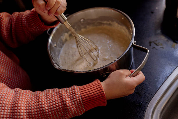 Child  whisking batter in metal bowl on kitchen counter in Amsterdam, North Holland, Netherlands